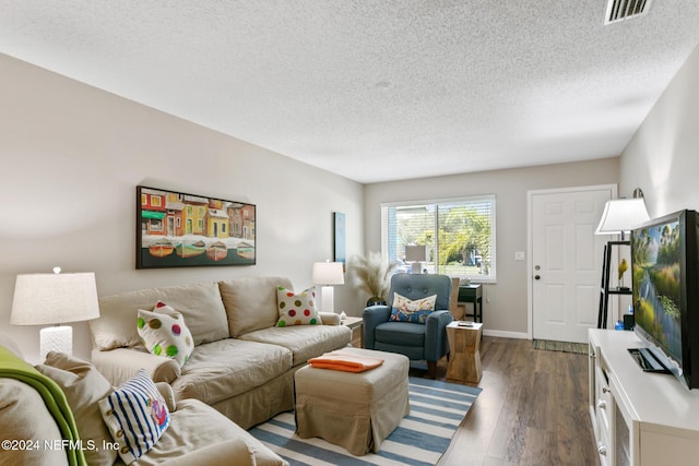 living room featuring dark hardwood / wood-style flooring and a textured ceiling