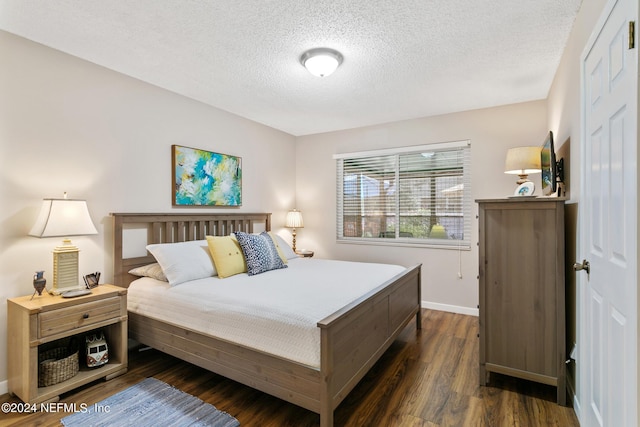 bedroom with a textured ceiling and dark hardwood / wood-style floors