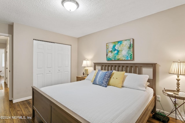 bedroom with a closet, dark wood-type flooring, and a textured ceiling