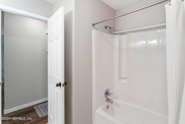 bathroom featuring shower / tub combo, a textured ceiling, and hardwood / wood-style floors