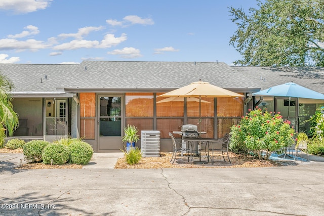 back of property with central AC and a patio