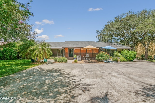 back of property with a lawn, a patio area, and central AC unit