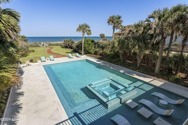 view of pool with a lawn, a patio area, an in ground hot tub, and a water view