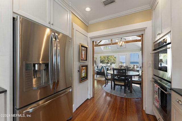 kitchen with white cabinets, stainless steel appliances, an inviting chandelier, and dark hardwood / wood-style floors