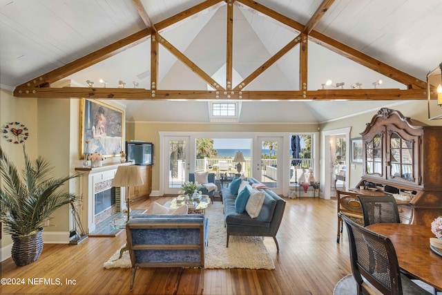 living room featuring beam ceiling, french doors, high vaulted ceiling, and light hardwood / wood-style flooring