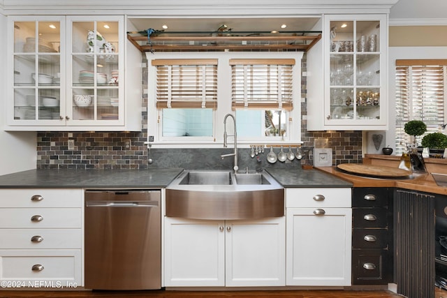 kitchen with white cabinets, decorative backsplash, stainless steel dishwasher, and sink