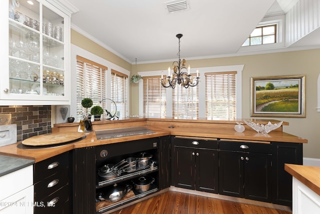 kitchen featuring white cabinets, black electric stovetop, and an inviting chandelier