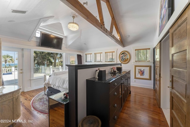 bedroom featuring access to exterior, wood-type flooring, and vaulted ceiling with beams