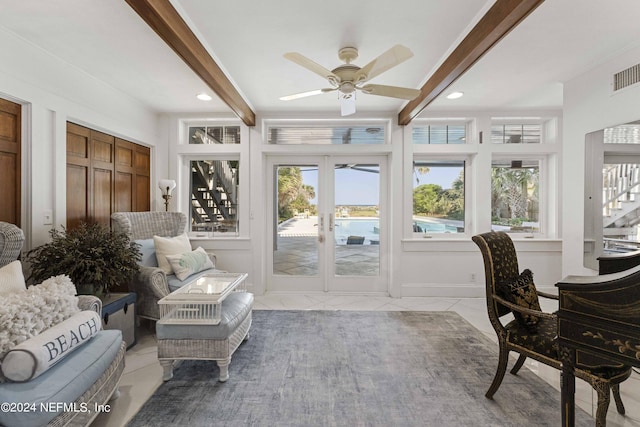 sunroom / solarium with beamed ceiling, ceiling fan, and french doors