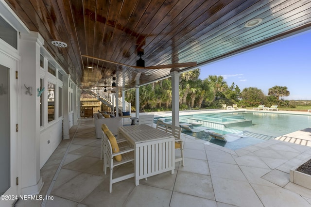 view of patio / terrace with a swimming pool with hot tub