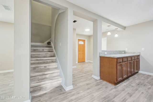 kitchen with decorative light fixtures and light wood-type flooring