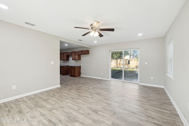 unfurnished living room with light hardwood / wood-style flooring and ceiling fan