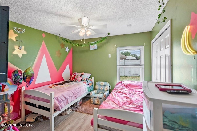 bedroom featuring hardwood / wood-style floors, ceiling fan, and a textured ceiling