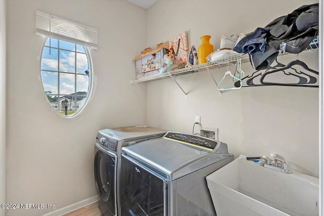 laundry area featuring hardwood / wood-style floors, independent washer and dryer, and sink