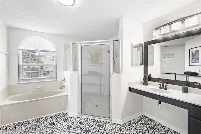 bathroom featuring sink, independent shower and bath, a textured ceiling, and tile patterned flooring