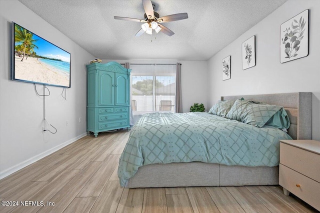 bedroom with a textured ceiling, light hardwood / wood-style floors, and ceiling fan