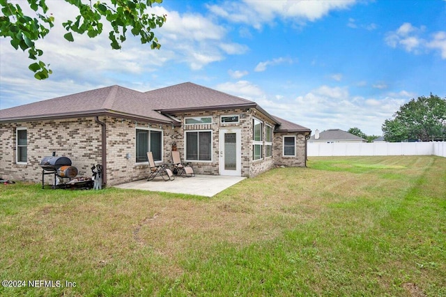 rear view of property with a yard and a patio