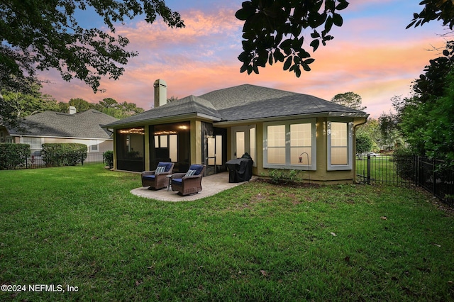 back house at dusk featuring a yard