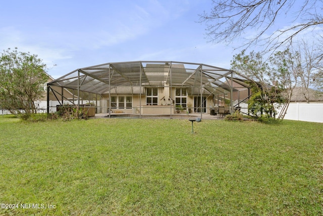 back of property featuring a yard and glass enclosure