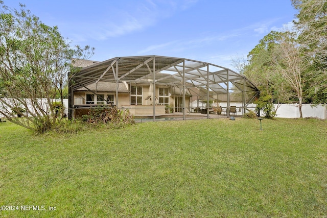 back of house featuring a lawn and a lanai