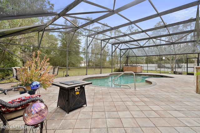 view of pool with a lanai, a patio, a hot tub, and an outdoor fire pit