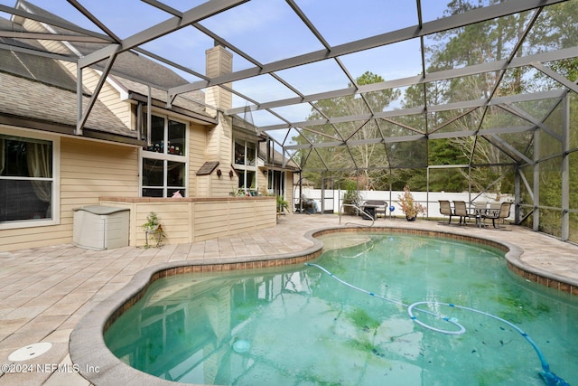 view of pool with a patio area and a lanai