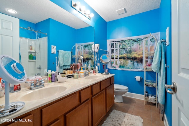 full bathroom with vanity, tile patterned floors, washtub / shower combination, toilet, and a textured ceiling