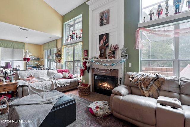 living room with a fireplace, vaulted ceiling, and a wealth of natural light