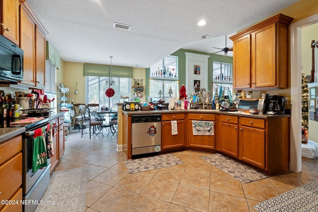 kitchen with ceiling fan, a textured ceiling, light tile patterned flooring, kitchen peninsula, and stainless steel appliances