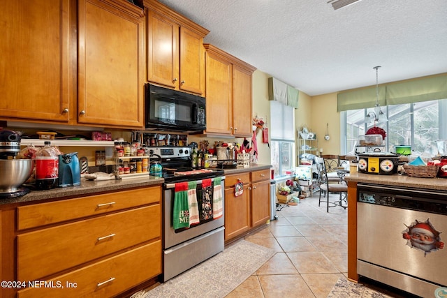 kitchen with decorative light fixtures, light tile patterned flooring, a textured ceiling, and appliances with stainless steel finishes