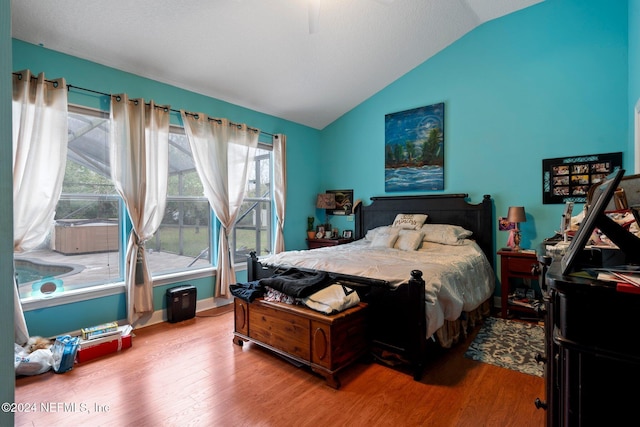 bedroom with ceiling fan, lofted ceiling, and hardwood / wood-style flooring