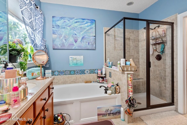 bathroom with vanity, shower with separate bathtub, and a textured ceiling