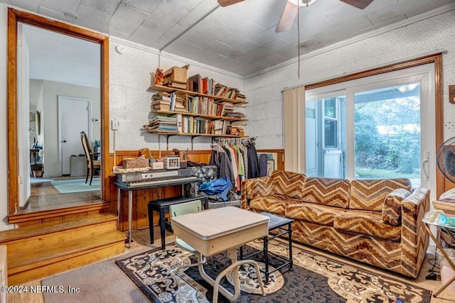 living area featuring crown molding and ceiling fan