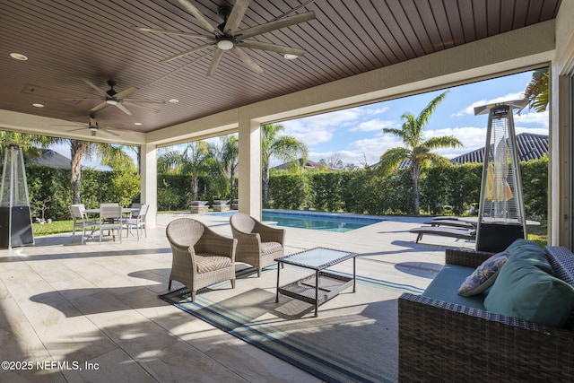 view of patio with a fenced in pool, an outdoor hangout area, and ceiling fan