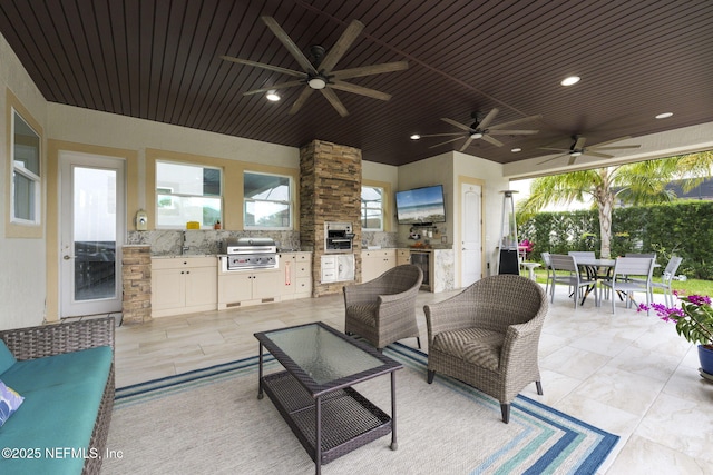 view of patio with wine cooler, grilling area, ceiling fan, an outdoor living space, and exterior kitchen