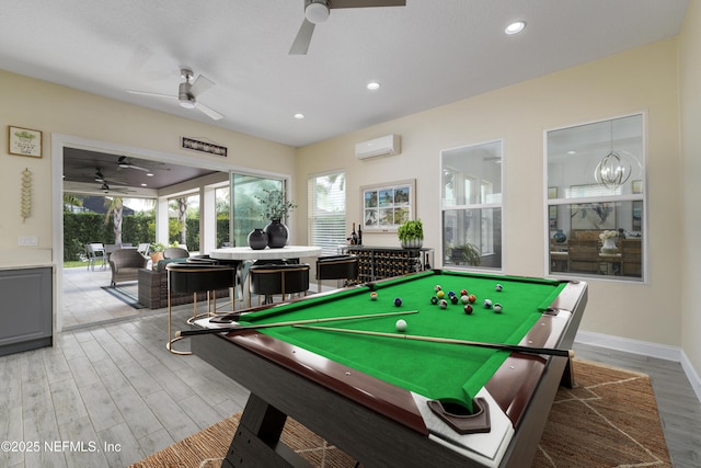 playroom featuring hardwood / wood-style floors, a wall mounted AC, a chandelier, and billiards