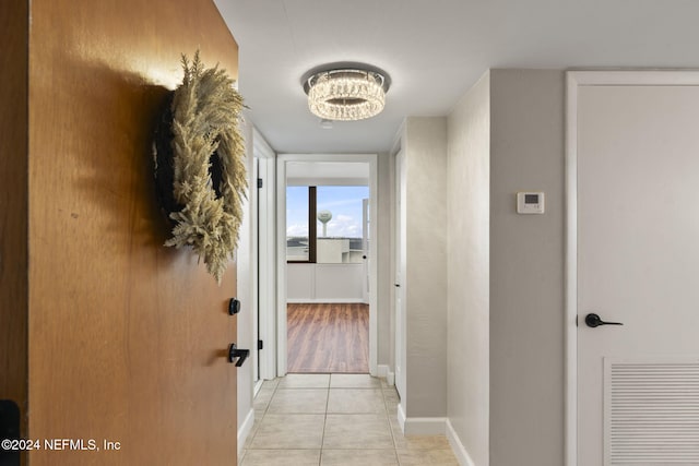 hall featuring light tile patterned floors and a chandelier