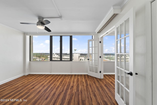 empty room featuring ceiling fan, dark hardwood / wood-style flooring, crown molding, and french doors