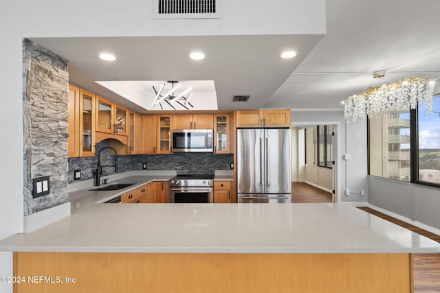 kitchen featuring decorative light fixtures, stainless steel appliances, a notable chandelier, and sink