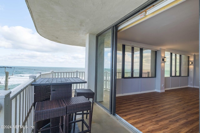 balcony featuring a water view and a view of the beach