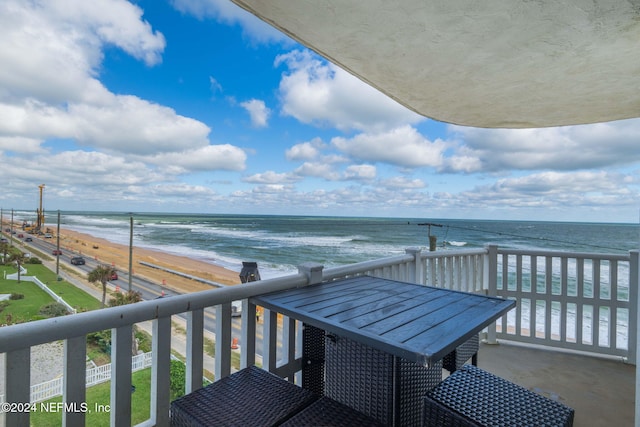 balcony featuring a water view and a beach view