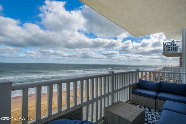 balcony featuring a view of the beach and a water view