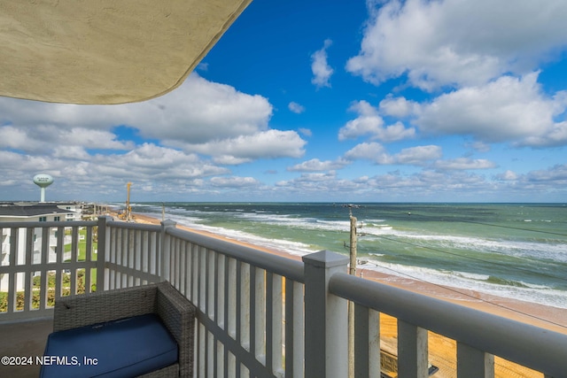 balcony with a water view and a view of the beach