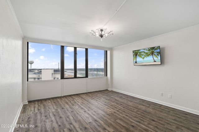 empty room with a notable chandelier, wood-type flooring, and ornamental molding