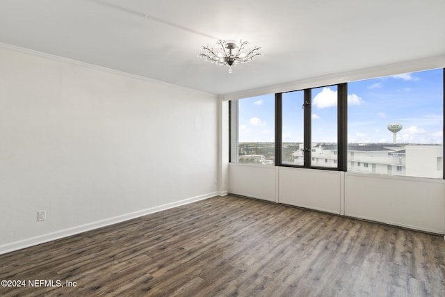 unfurnished room with wood-type flooring, an inviting chandelier, and ornamental molding