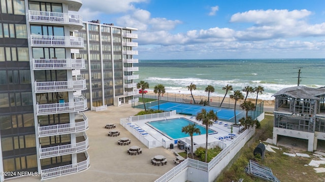 view of pool with a water view and a beach view