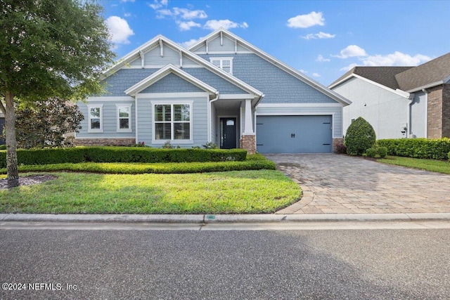 craftsman house with a front yard and a garage