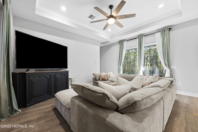 living room featuring a raised ceiling, ceiling fan, dark hardwood / wood-style floors, and ornamental molding