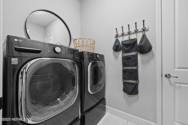 washroom with light tile patterned floors and washing machine and dryer