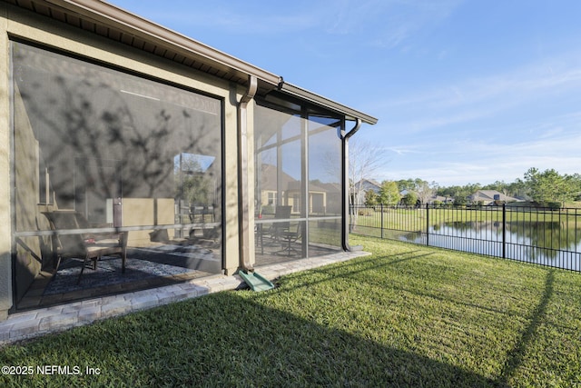 view of yard featuring a water view and a sunroom